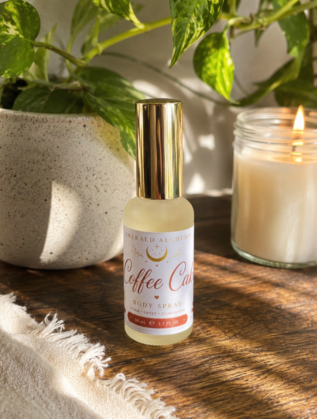 Coffee Cake body spray 50 mL in a warm botanical setting
