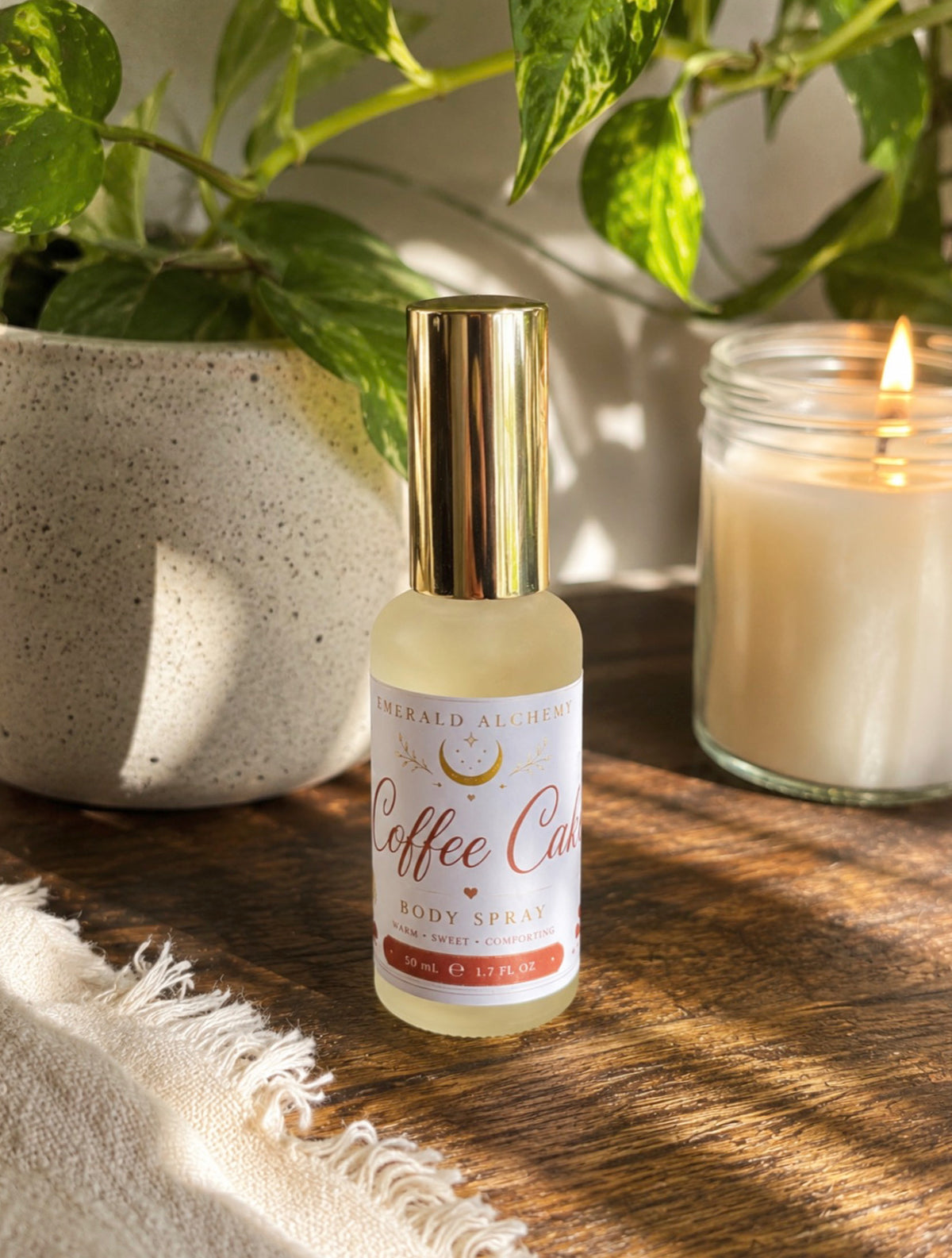 Coffee Cake body spray 50 mL in a warm botanical setting