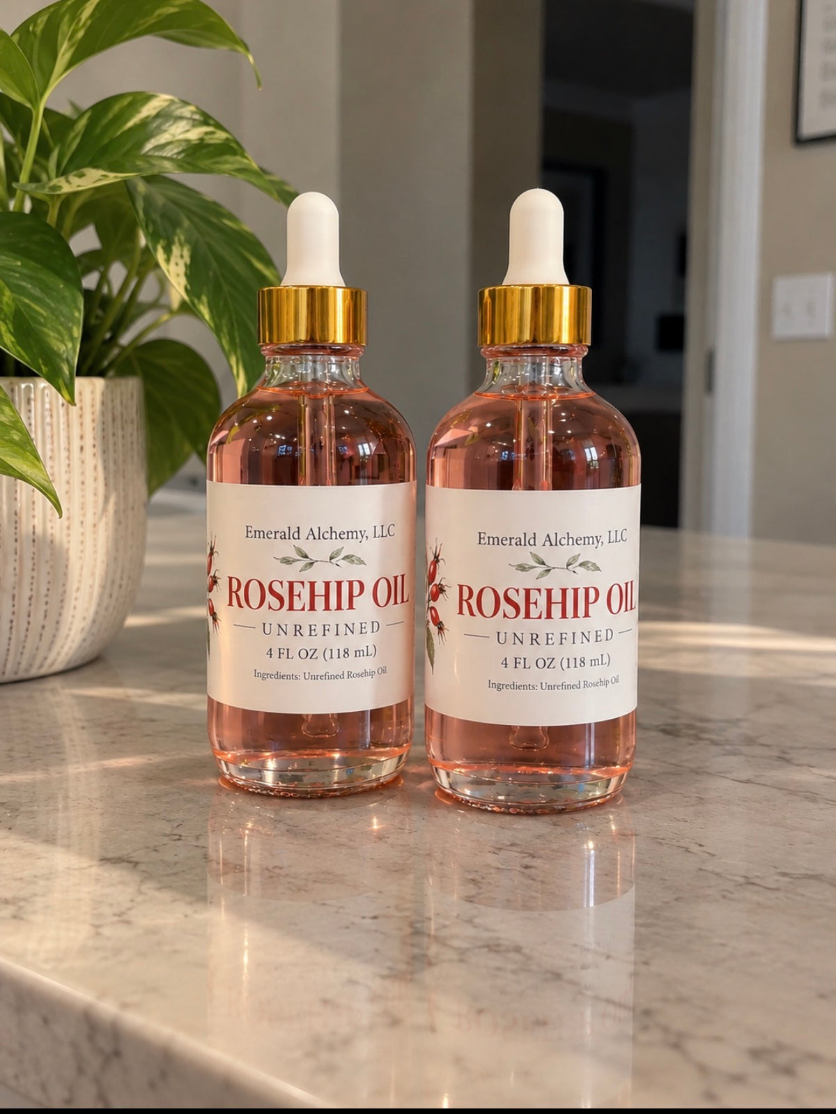 Two 4 oz bottles of unrefined Rosehip Oil displayed beside greenery