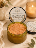 Teakwood Mahogany Sugar Body Scrub 8 oz open jar with labeled lids and candle